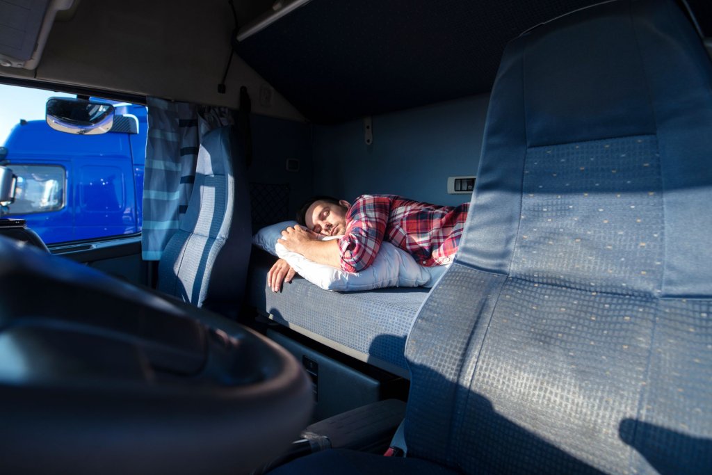 A truck driver sleeping in his truck